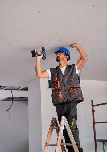Certified building inspector repairing ceiling during a structural assessment in Cannonvale, Queensland.